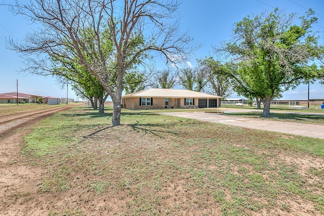 7077 Bean Rd, Wall, TX 76957 - ranch-style home with concrete driveway, a front yard, and brick siding