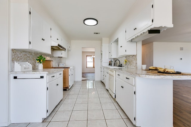 7077 Bean Rd, Wall, TX 76957 - kitchen with light countertops, decorative backsplash, under cabinet range hood, and white cabinets