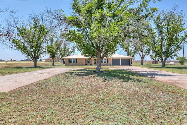 7077 Bean Rd, Wall, TX 76957 - ranch-style home with driveway, a front lawn, and metal roof