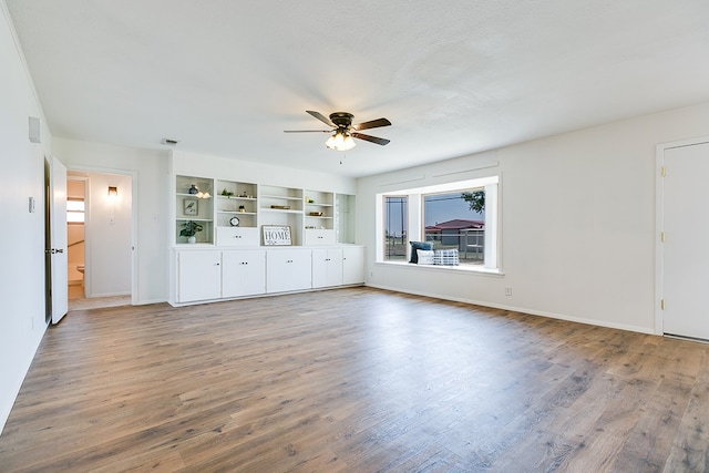 7077 Bean Rd, Wall, TX 76957 - unfurnished living room featuring a ceiling fan, wood finished floors, and baseboards