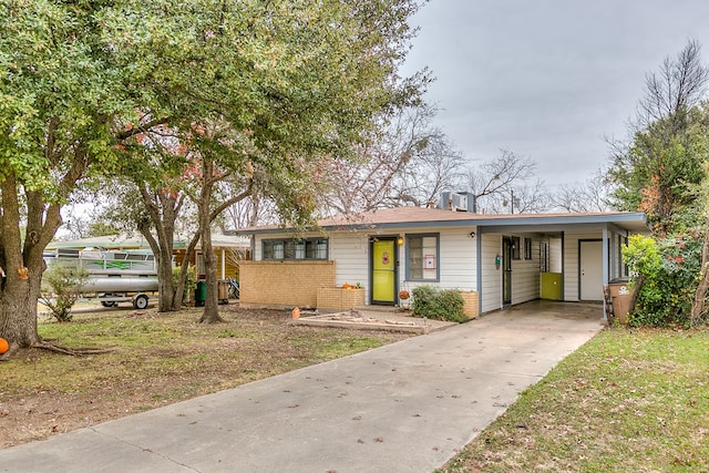 ranch-style house featuring a carport and a front yard