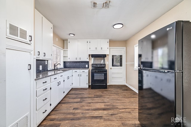 2105 Coleman St, San Angelo, TX 76901 - kitchen with black appliances, open shelves, dark stone countertops, white cabinets, and range hood