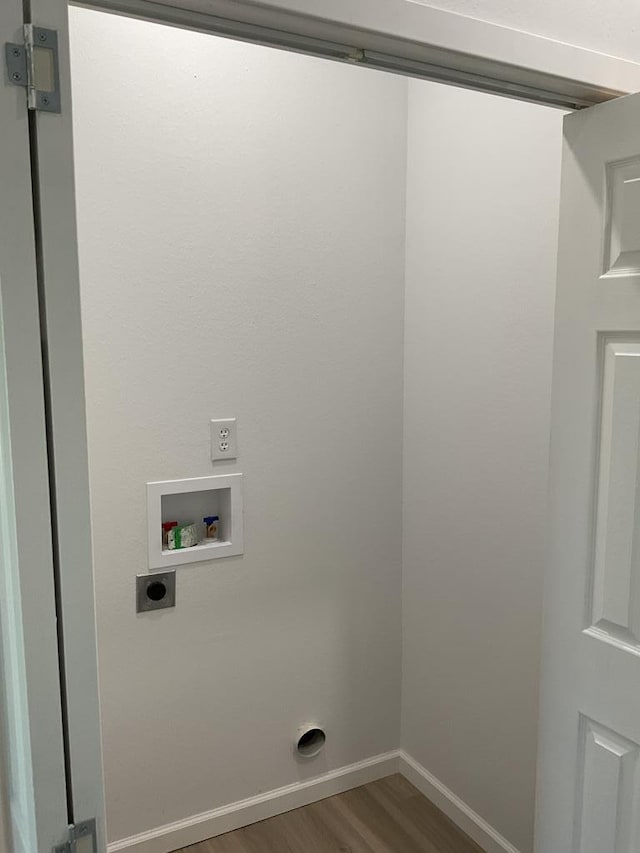 709 E Harris Ave, San Angelo, TX 76903 - laundry area with wood finished floors, electric dryer hookup, washer hookup, and baseboards
