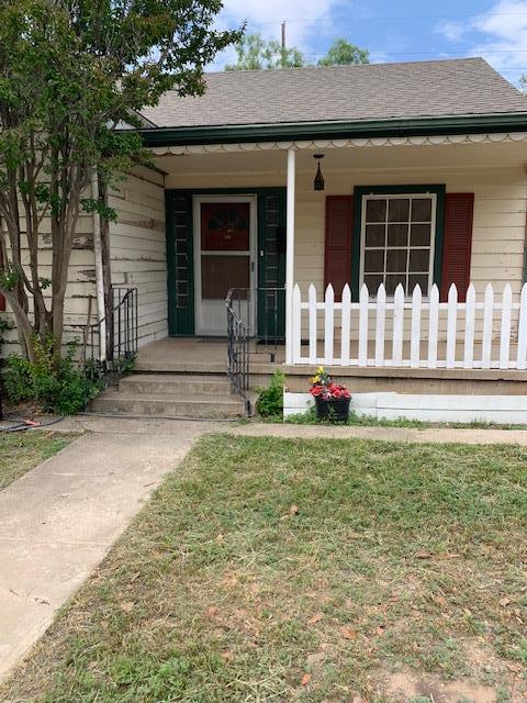 217 S Monroe St, San Angelo, TX 76901 - view of front of home with covered porch, roof with shingles, and a front lawn