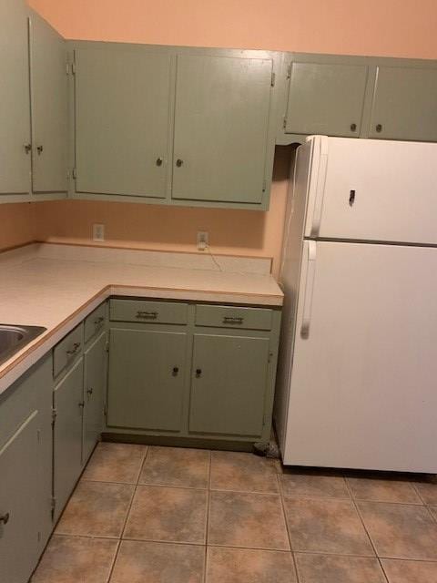 217 S Monroe St, San Angelo, TX 76901 - kitchen featuring freestanding refrigerator, light countertops, light tile patterned flooring, and a sink