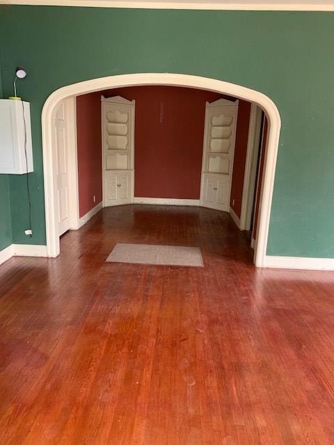 217 S Monroe St, San Angelo, TX 76901 - spare room featuring wood finished floors, baseboards, and arched walkways