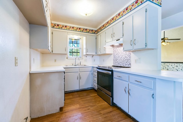 2756 Eunice Dr, San Angelo, TX 76901 - kitchen featuring stainless steel range with electric cooktop, under cabinet range hood, dark wood-style floors, light countertops, and decorative backsplash