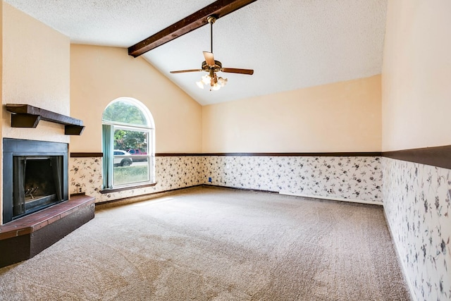 2756 Eunice Dr, San Angelo, TX 76901 - unfurnished living room featuring carpet floors, a fireplace with raised hearth, a wainscoted wall, a ceiling fan, and a textured ceiling