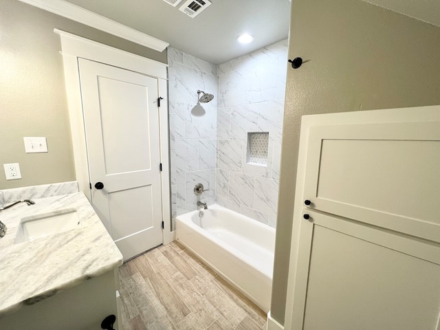 bathroom with vanity, tiled shower / bath combo, and hardwood / wood-style floors