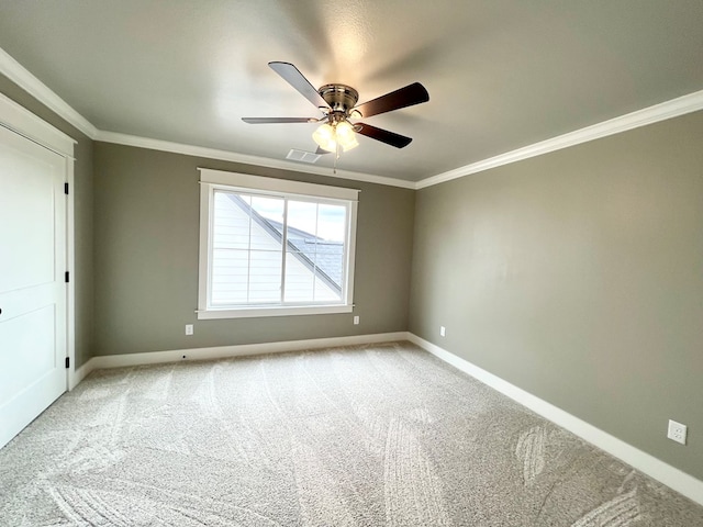 carpeted spare room with ceiling fan and ornamental molding