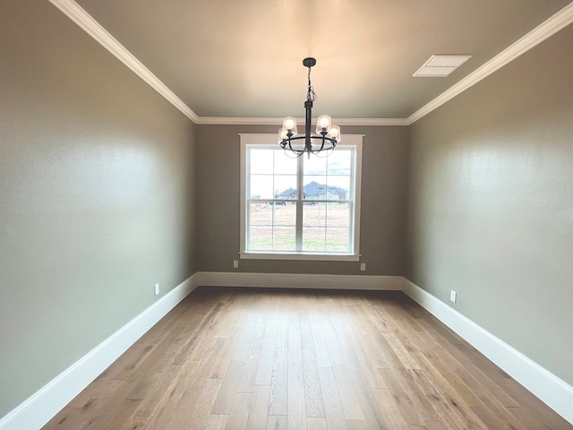 empty room featuring ornamental molding, light hardwood / wood-style floors, and a notable chandelier