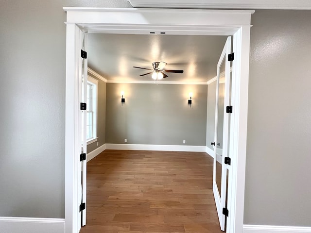 empty room with ornamental molding, hardwood / wood-style floors, and ceiling fan