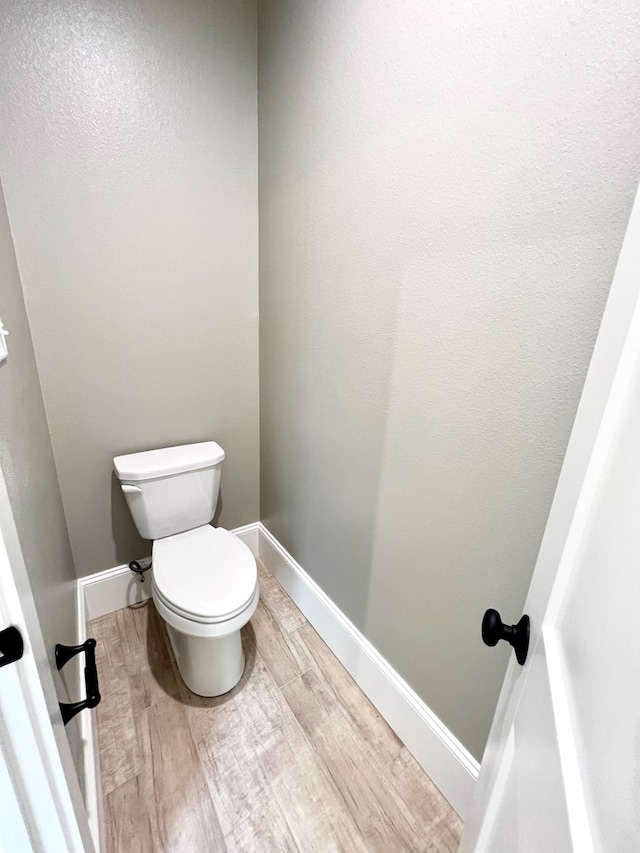 bathroom featuring hardwood / wood-style flooring and toilet