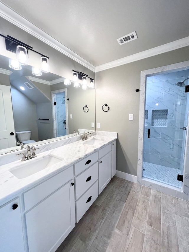 bathroom with ornamental molding, toilet, an enclosed shower, and vanity