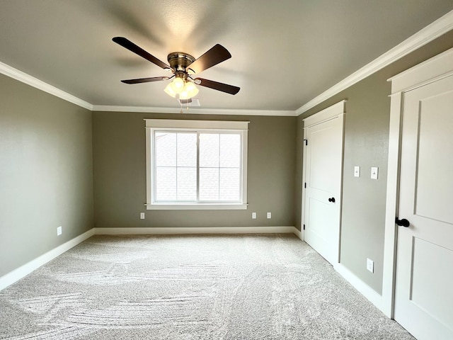 carpeted spare room featuring crown molding and ceiling fan