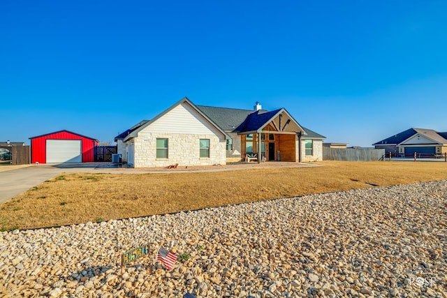 view of front of house featuring a garage, an outdoor structure, and a front lawn