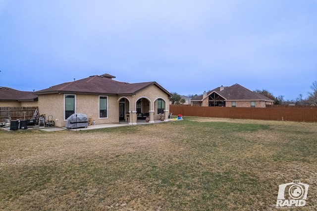 rear view of property with a yard and a patio area