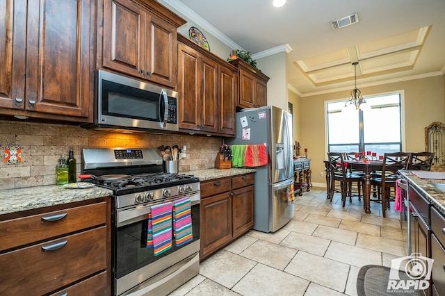 kitchen with pendant lighting, stainless steel appliances, light stone counters, ornamental molding, and decorative backsplash