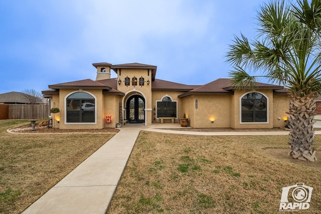 mediterranean / spanish house with french doors and a front lawn