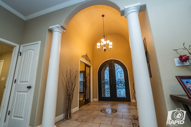 entrance foyer featuring an inviting chandelier, crown molding, french doors, and ornate columns