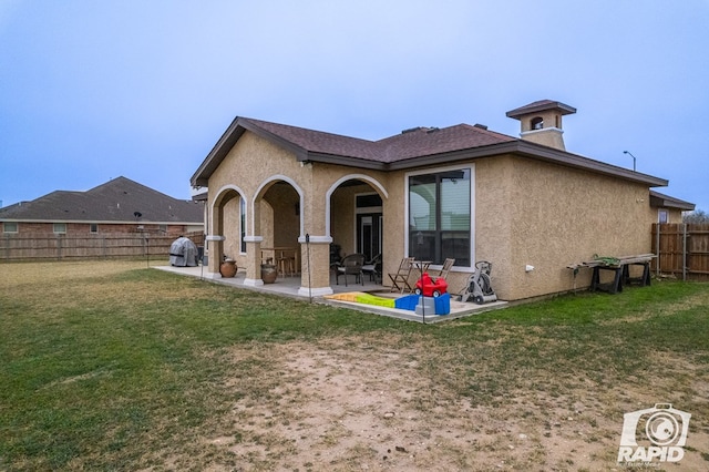 back of house with a patio and a yard