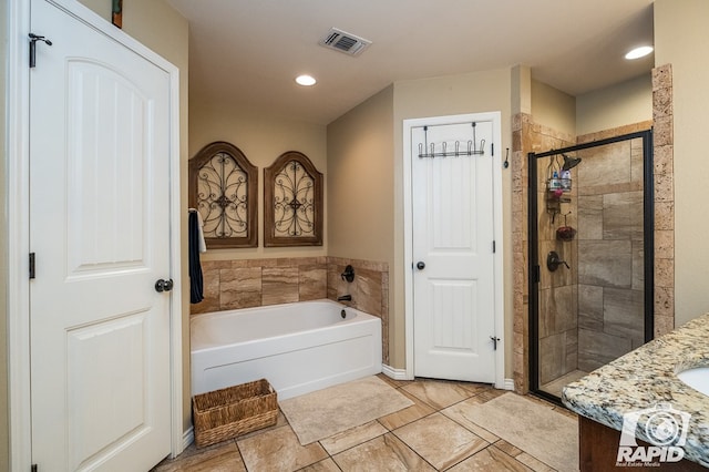 bathroom featuring vanity and independent shower and bath