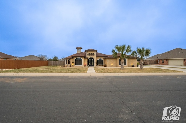 mediterranean / spanish-style house with a front lawn