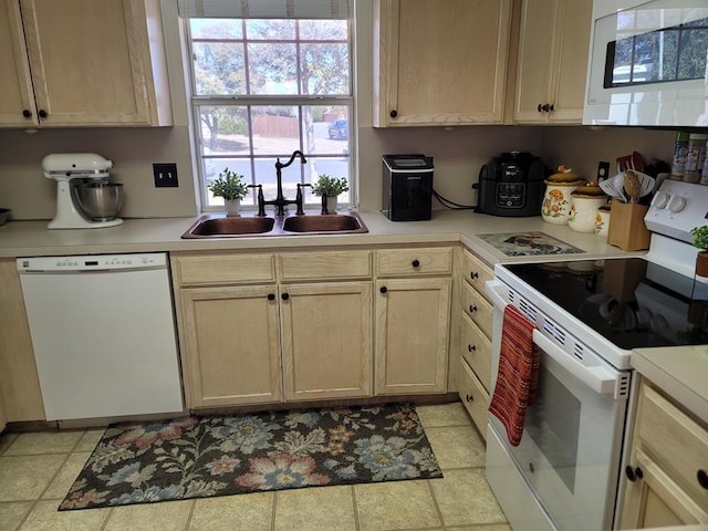 kitchen featuring a sink, white appliances, and light countertops