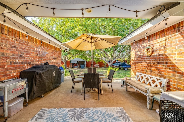 view of patio with outdoor dining area and grilling area