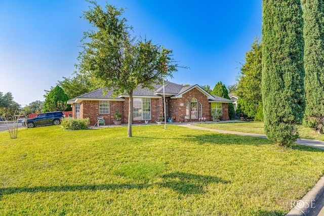 ranch-style house with a front lawn and brick siding