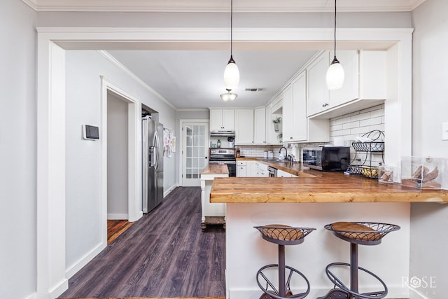 1601 S Jackson St, San Angelo, TX 76903 - kitchen featuring appliances with stainless steel finishes, butcher block countertops, a sink, a peninsula, and dark wood finished floors