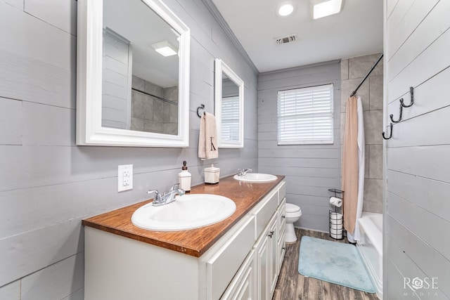 1601 S Jackson St, San Angelo, TX 76903 - full bathroom with double vanity, toilet, shower / bath combo, and wood finished floors