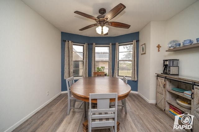 dining room featuring baseboards, ceiling fan, and wood finished floors