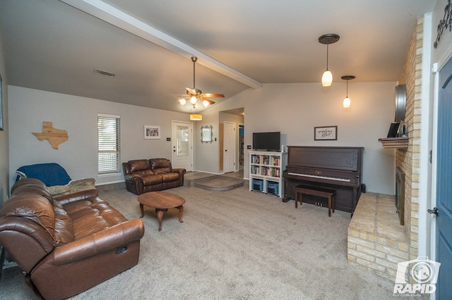 carpeted living area with vaulted ceiling with beams, a brick fireplace, visible vents, and ceiling fan