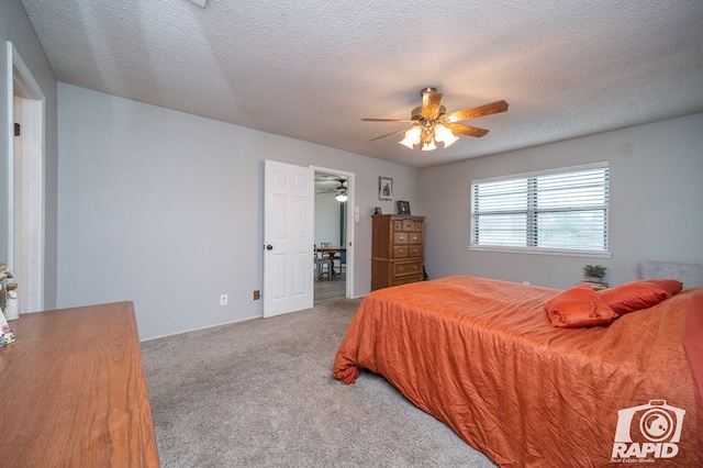carpeted bedroom with a textured ceiling and a ceiling fan
