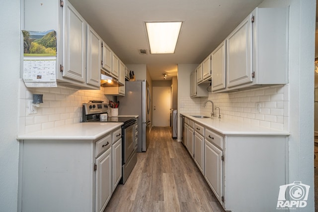 kitchen with tasteful backsplash, stainless steel range with electric stovetop, a sink, light wood-type flooring, and under cabinet range hood