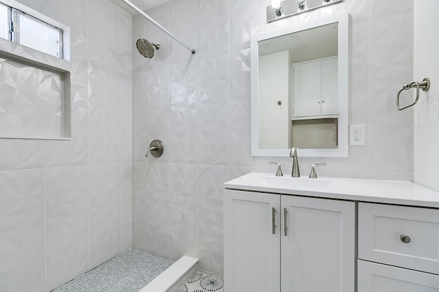 bathroom featuring vanity, a tile shower, and tile walls