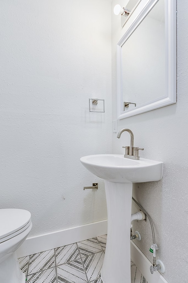 bathroom featuring toilet and tile patterned flooring