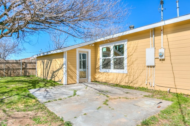 property entrance featuring a patio and a lawn