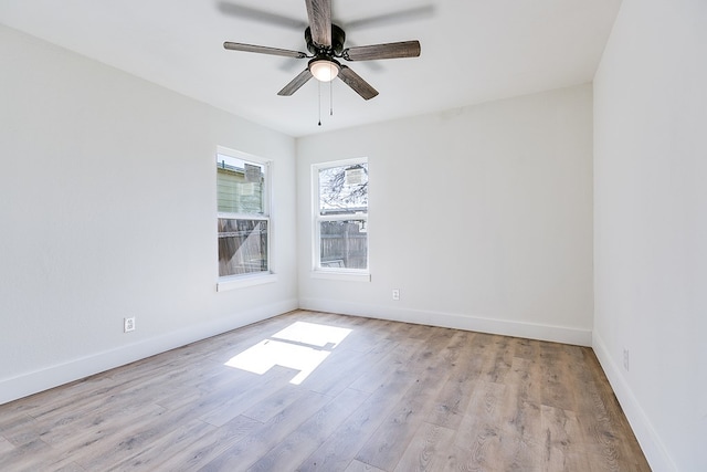 empty room with ceiling fan and light hardwood / wood-style flooring