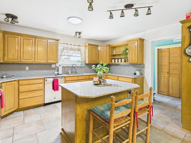675 Buffalo Ln, San Angelo, TX 76901 - kitchen with dishwasher, tasteful backsplash, a kitchen island, open shelves, and a breakfast bar area