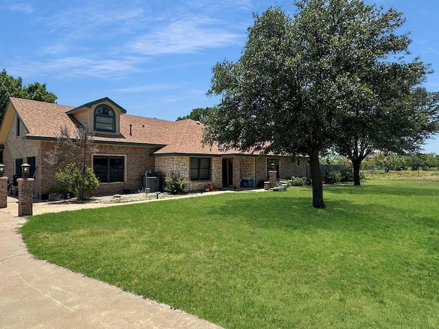 675 Buffalo Ln, San Angelo, TX 76901 - view of front facade featuring a front yard, stone siding, and a shingled roof