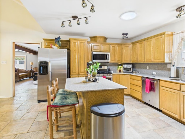675 Buffalo Ln, San Angelo, TX 76901 - kitchen with stainless steel appliances, stone tile flooring, a kitchen island, and backsplash