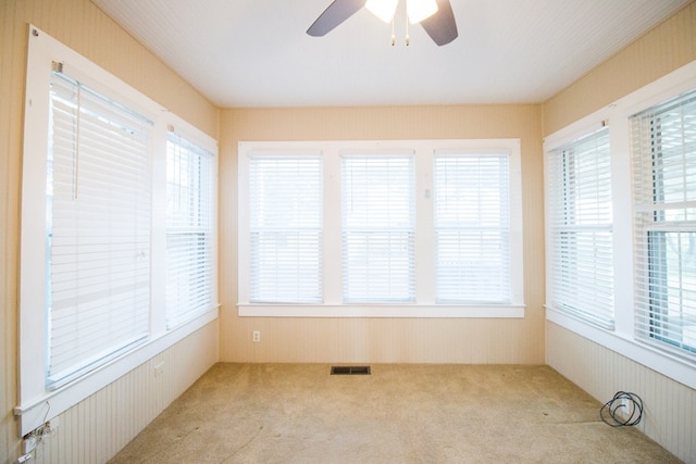 unfurnished sunroom featuring ceiling fan