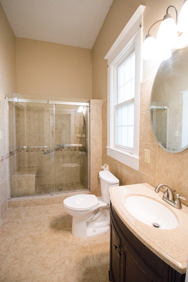 bathroom with vanity, a shower with shower door, tile patterned floors, and toilet