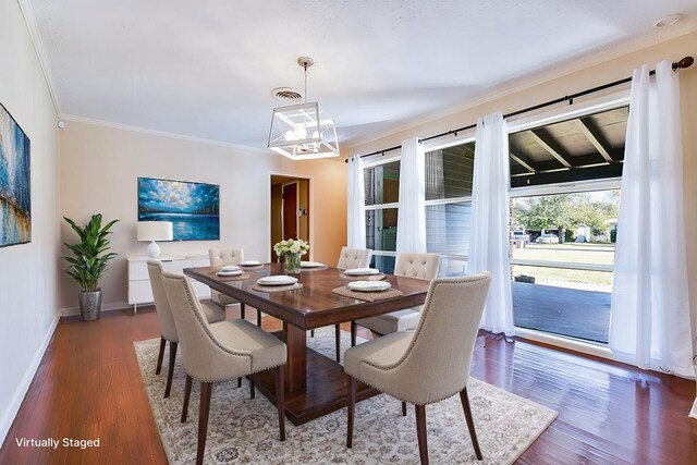 dining space with dark hardwood / wood-style flooring, crown molding, and an inviting chandelier