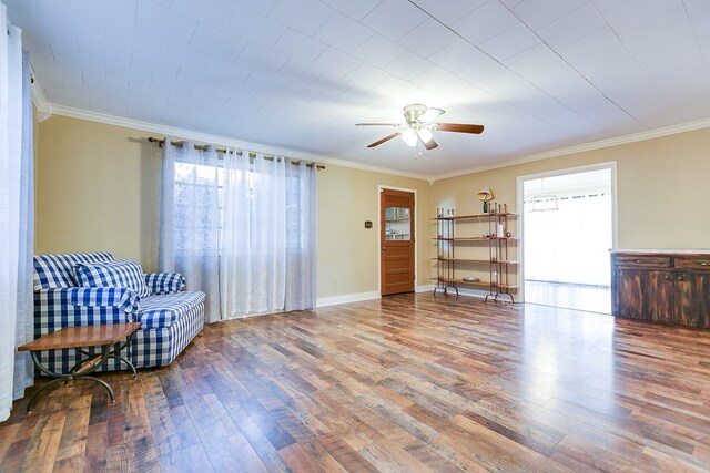 living area featuring hardwood / wood-style floors, ornamental molding, and ceiling fan