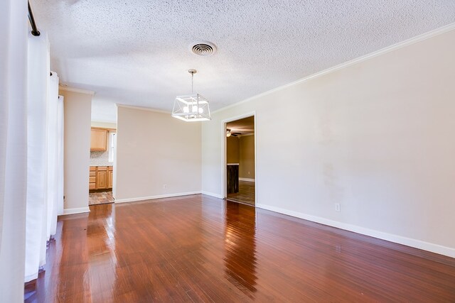 unfurnished room featuring ornamental molding, dark hardwood / wood-style floors, and a textured ceiling