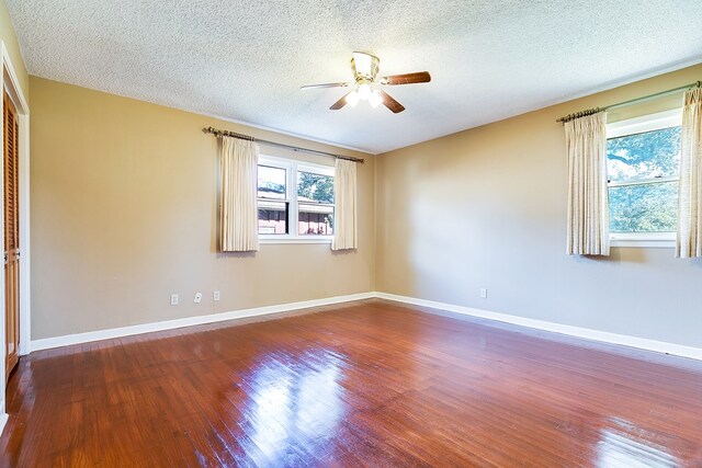 empty room featuring a textured ceiling, wood-type flooring, and ceiling fan