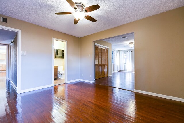 unfurnished room featuring dark wood-type flooring, ceiling fan, and a textured ceiling